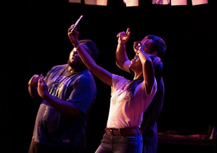 three actors on stage take a selfie