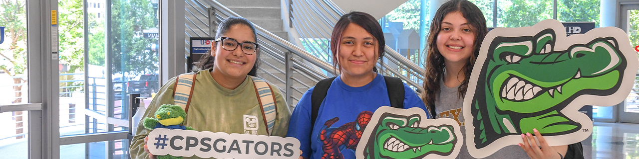 Three students smiling inside the commerce buildling