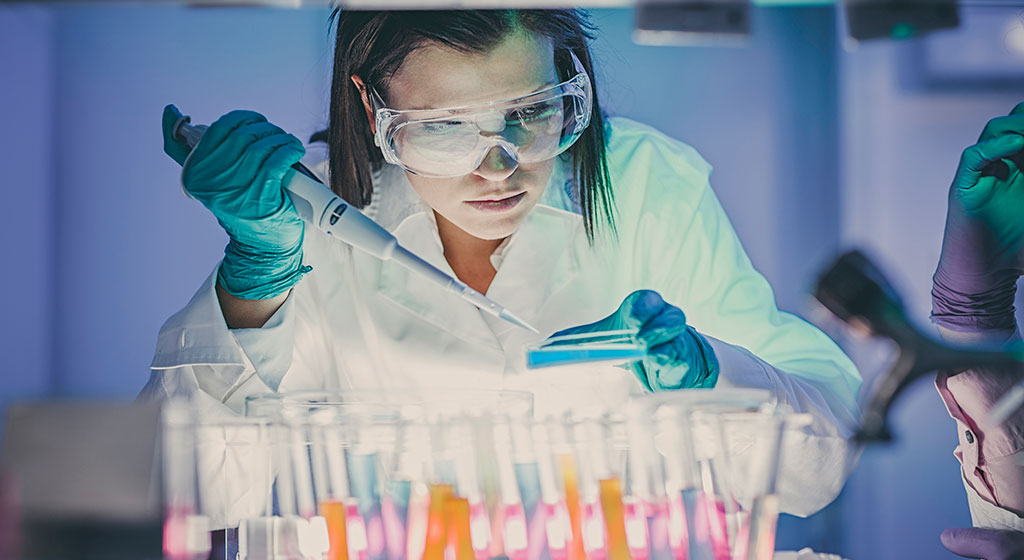 Woman adding something to a petri dish.