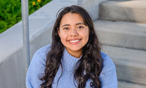 Freshman student sitting on stairs and smiling
