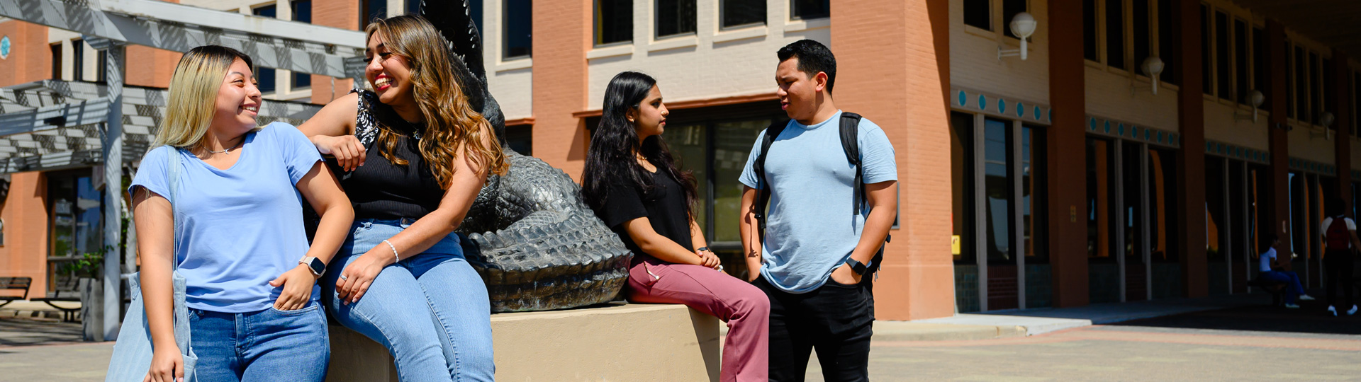 UHD students smiling and talking on the portico