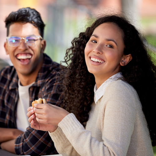 two fcollege students having a snack on campus