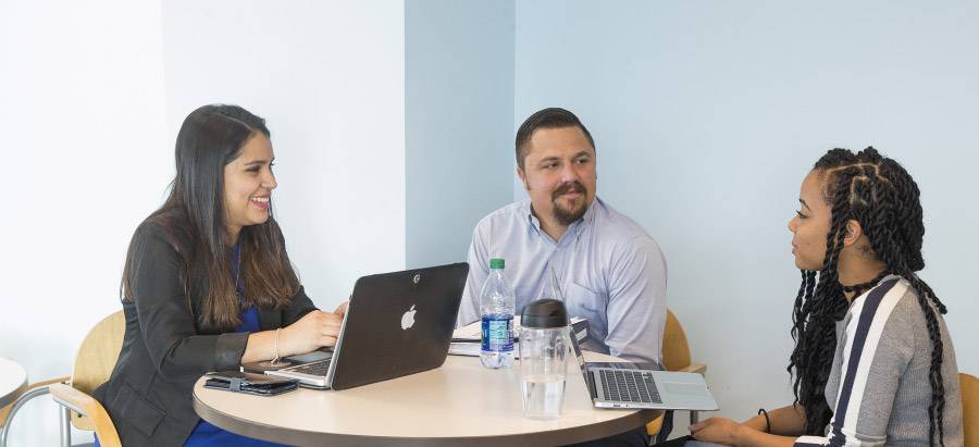 Decorative image of students sitting in an office space collaborating.