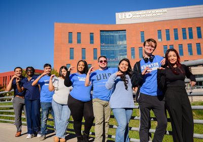 UHD students on campus doing the Gator sign