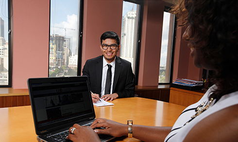 two people in board room with laptop