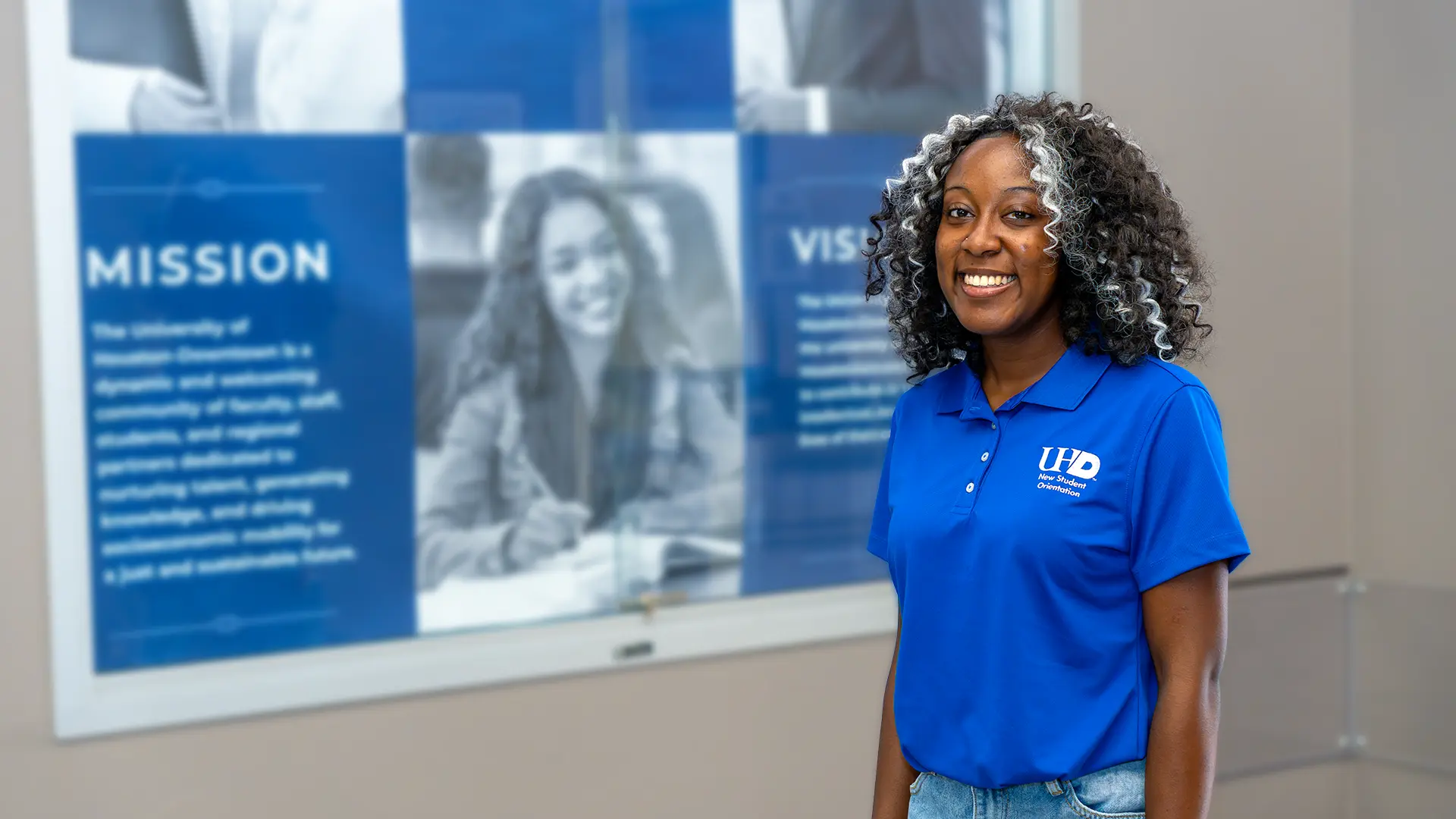Student holding booksFemale student wearing a blue polo shirt
