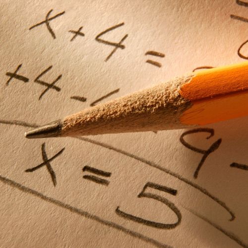 algebra equations on paper with a pencil resting on top