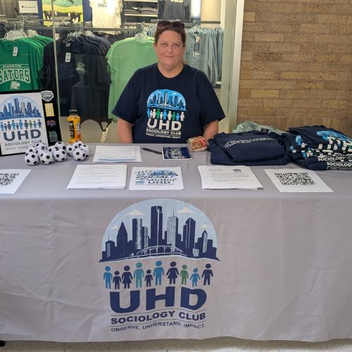 Rita Grove sitting at a table promoting Sociology Club