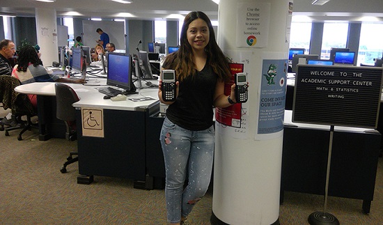 women in computer lab holding two calculators