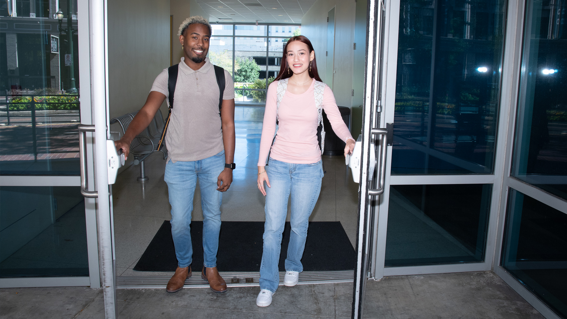 Two UHD studenting opening double doors at the CPS building