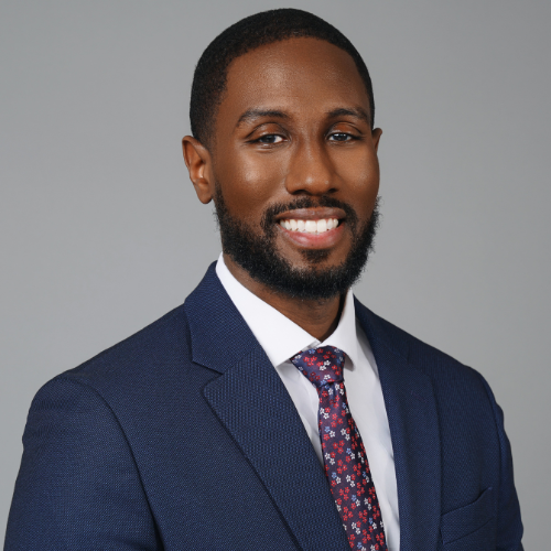 Darius Benton smiles while wearing a suit and tie