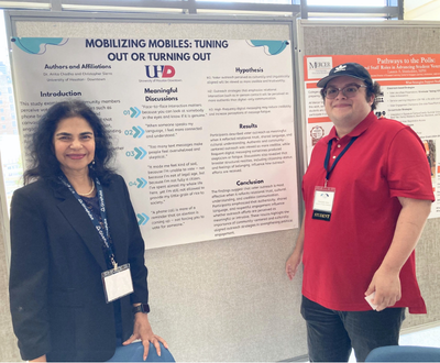 Dr. Chadha and Christopher Sierra smile next to a research poster that reads 