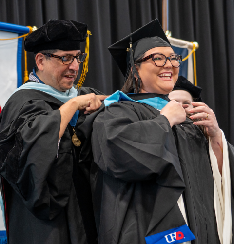 A graduate student is hooded by a faculty member at the university of houston-downtown