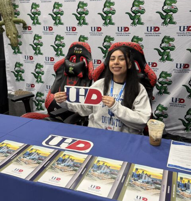 A University of Houston-Downtown student holds up a paper with the UHD logo at the university's esports table at Comicpalooza in Houston, Texas.